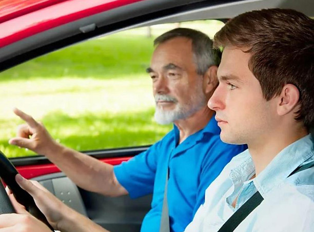 Driving instructor training a young driver